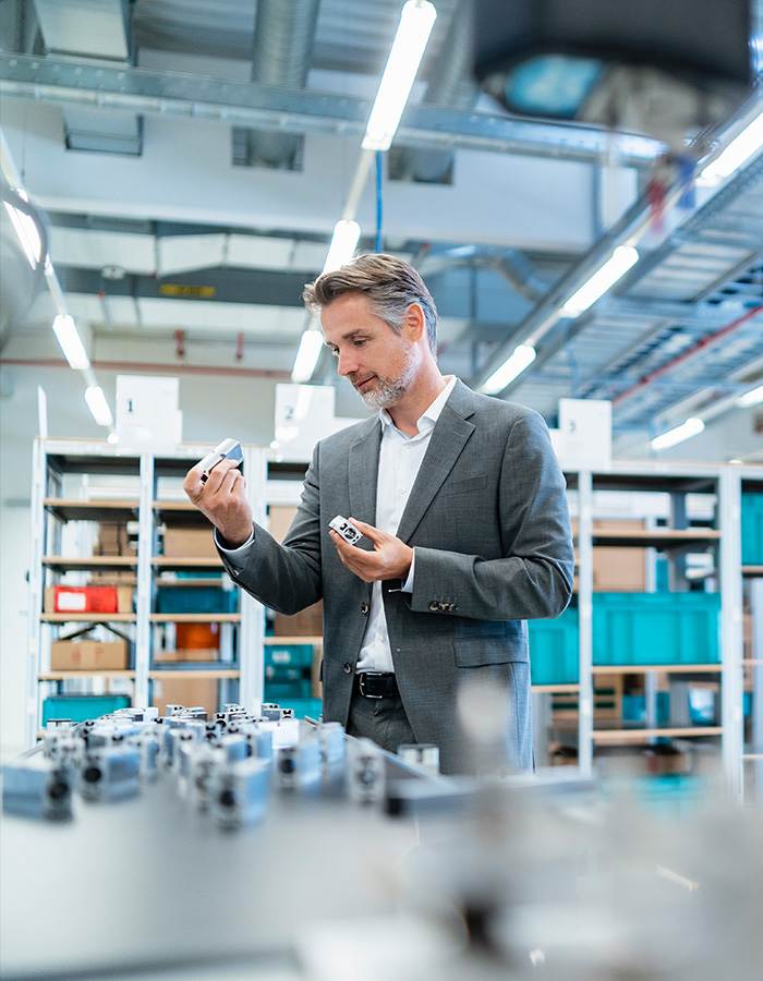businessman examining workpieces in a modern facto 4LDLQQ2