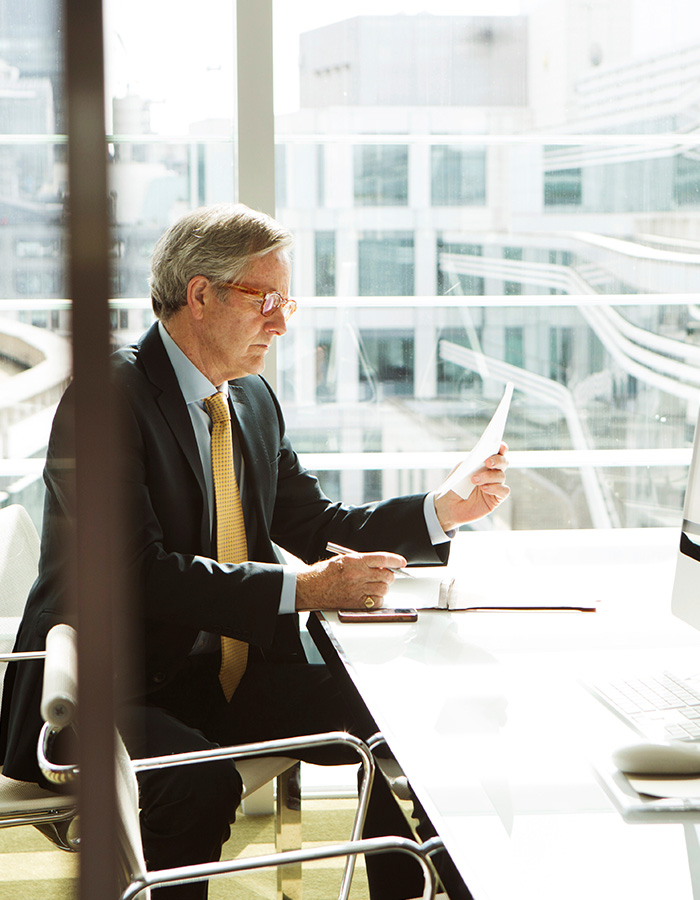 businessman reviewing documents in a modern office LXZ83UW